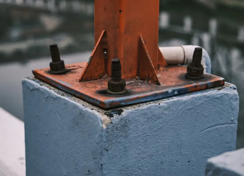 A pole-mounted camera station on a concrete block beside the runway strip